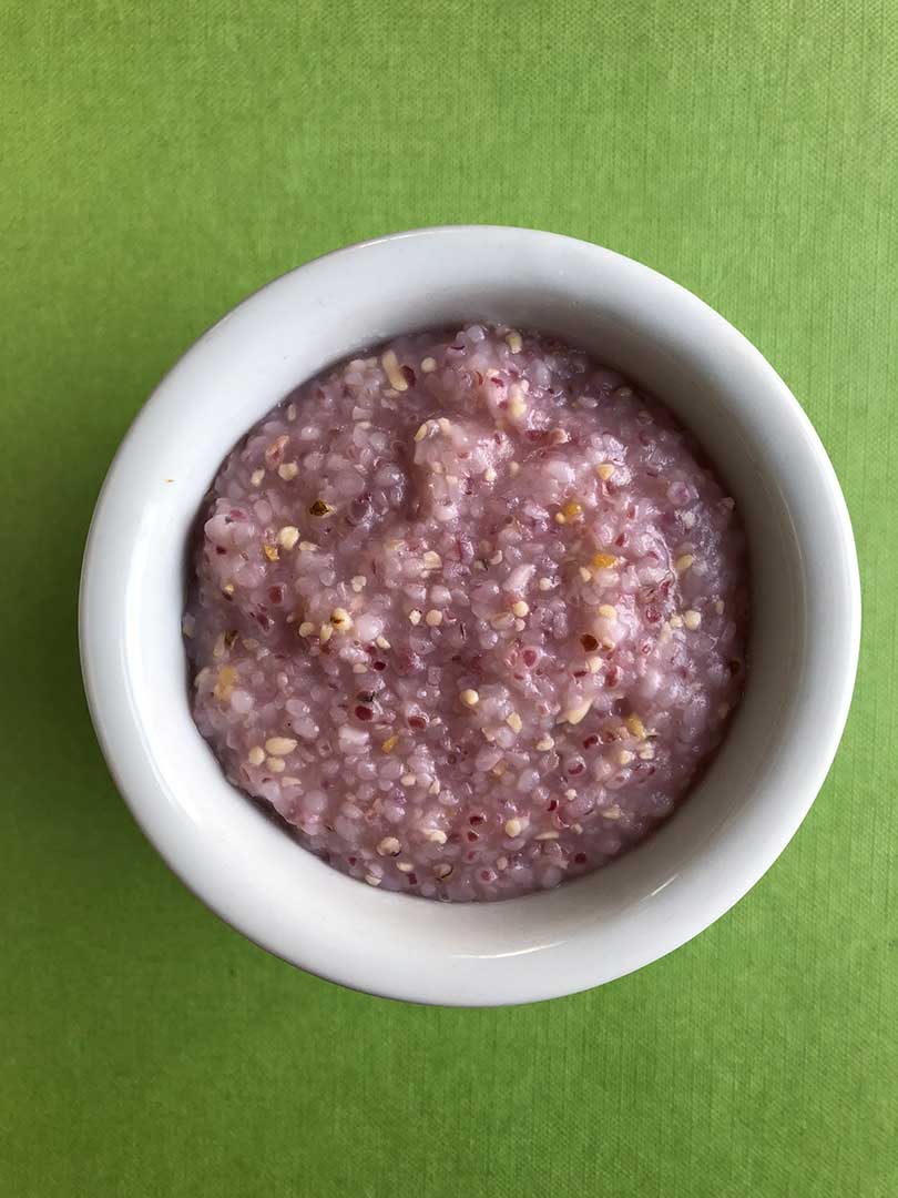 Cooked pink grits in a white bowl
