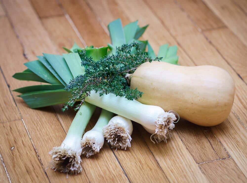 Leeks, butternut squash, and thyme on a table