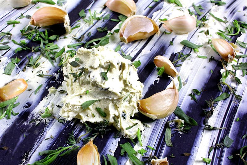 CrumbleBerry-Cashew-Hemp-Garlic-Chive-Dill-Cashew-Cheese CrumbleBerry Hemp Garlic Chive Dill Cashew Cheese with garlic cloves on a blanket