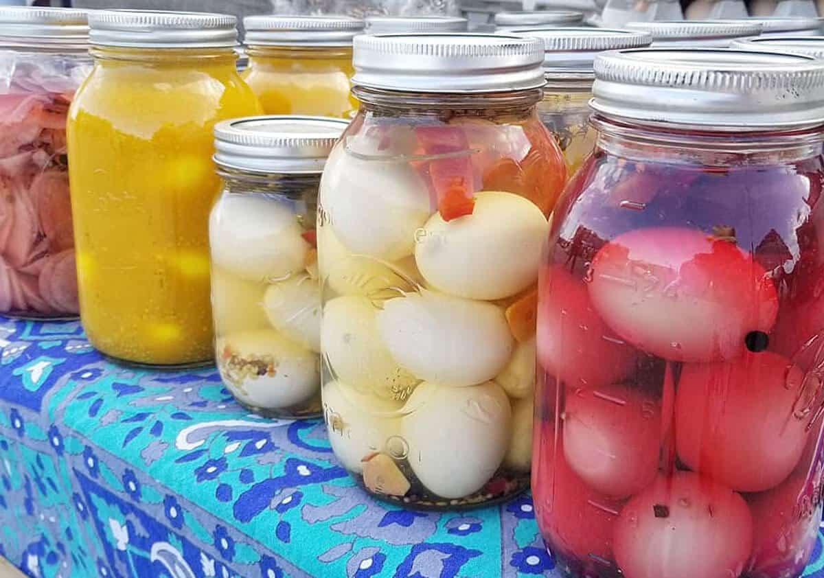 Various flavors of pickled eggs in jars